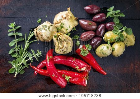 Traditional Italian Antipasti with Vegetable and Olives as top view on old burnt cutting board