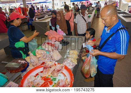 Keningau,Sabah,Malaysia-June 29,2017:Local man buy chicken meat at the local market Tamu in Keningau,Sabah.Its a place where all farmers,fishermen & vendors gathers weekly to sell their products