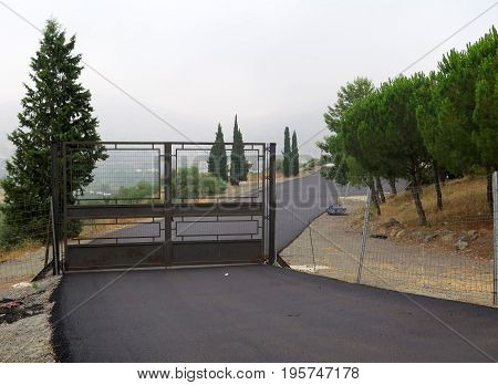 Steel Gate and tarmacked road in Andalusian village