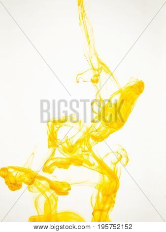 Ink swirl in a water on white background. The paint splash in the water. Soft dissemination a droplets of colored ink in water close-up. Abstract background. Explosion of color splashes acrylic ink.