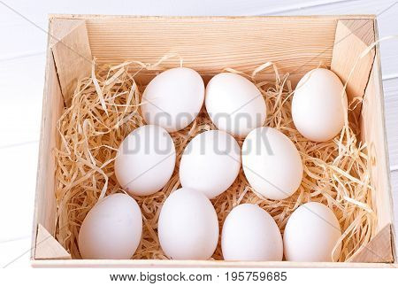 EA dozen white eggs in a wooden box