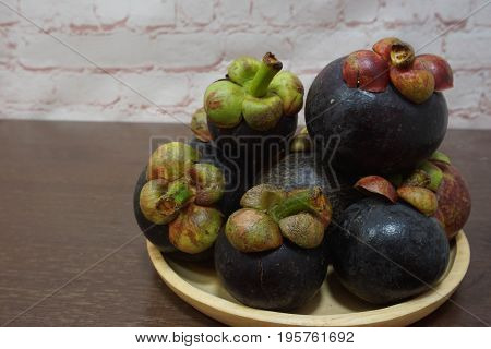 Mangosteens on wooden plate  :   the queen of friuts of Thailand
copy space