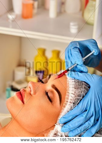 Filler injection for woman forehead face. Plastic aesthetic facial surgery by doctor in beauty clinic. Removing wrinkles with help of new technologies. Restoration of facial skin.