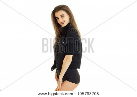 Chereful young girl in black panties and jacket smiles on camera isolated on white background
