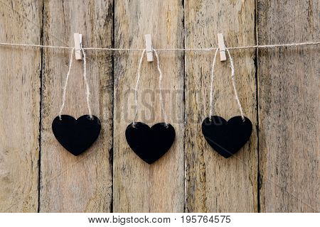 Three Heart Shape Blackboards Hanging On Clothespin On String Against Rustic Wood Background
