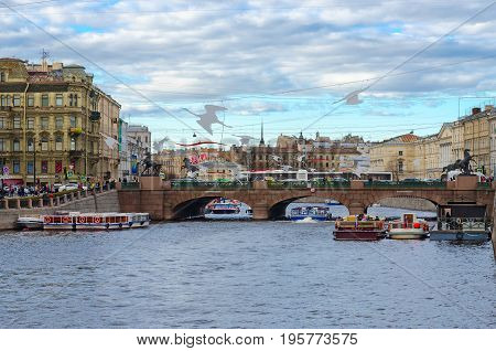SAINT PETERSBURG RUSSIA - MAY 3 2017: Unknown tourists are on excursion boats on Fontanka River near Anichkov Bridge St. Petersburg Russia