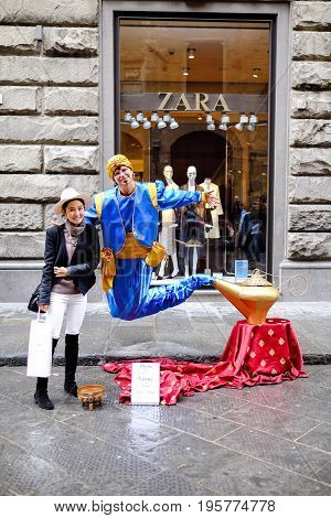 FLORENCE, ITALY - MARCH 27: A Asian tourist taking a photo with Genie and the Magic Lamp street performer in Florence, Italy on March 27, 2015