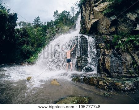 Man in Kamyshlinskiy vodopad waterfall summer, mountains Altai, Russia.