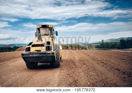 Vibratory Soil Compactor During Highway Building. Industrial Roadworks With Heavy-duty Machinery