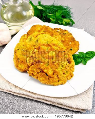 Indian chick-pea flour flatbreads with zucchini and fresh herbs, basil in a plate on a napkin, garlic and oil in a decanter, dill on the background of a granite table