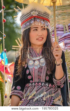 CHIANGMAI THAILAND - JANUARY 25 2015: Hill tribe girl holding white paper umbrella in parade of 22nd Traditional Skirt Fabric and The Indigenous Product and Culture Festival in Mae Chaem Chiangmai Thailand