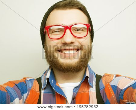 Tehnology concept: Happy selfie. Handsome young man  holding camera and making selfie and smiling.
