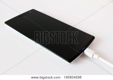 Mobile smartphone is charging with graphic on it screen