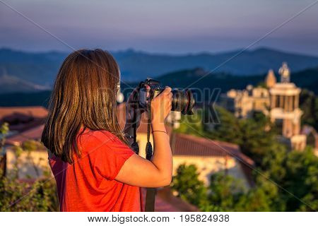 Girl taking of areal view photo at the sunset from high mountain of the Signaghi, Georgia.