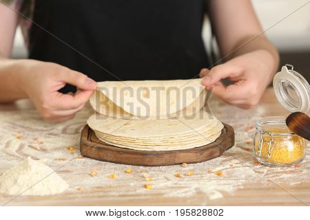 Chef cooking delicious unleavened tortillas on wooden table