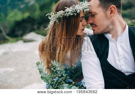 bride with a beautiful wreath of white flowers and the groom standing face to face