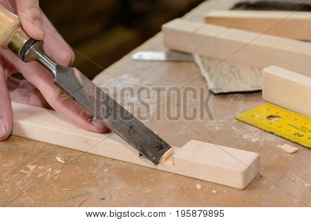 Worker working the wooden tool chisels - close up