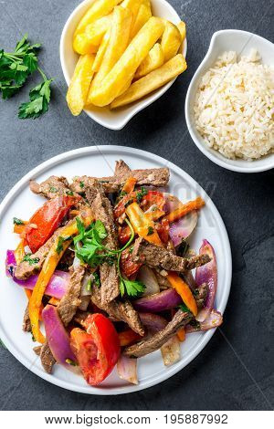 Peruvian Dish Lomo Saltado - Beef Tenderloin With Purple Onion, Yellow Chili, Tomatoes Served On Whi
