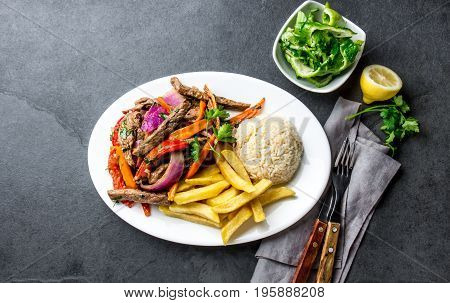 Peruvian Dish Lomo Saltado - Beef Tenderloin With Purple Onion, Yellow Chili, Tomatoes Served On Whi