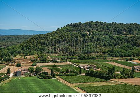 Panoramic view of the fields and hills of Provence near Ménerbes, under sunny blue sky. Located in the Vaucluse department, Provence-Alpes-Côte d'Azur region, southeastern France