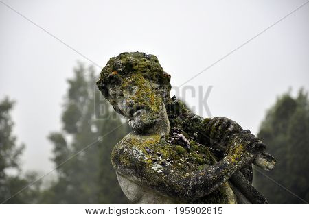 statue covered in moss in a park France