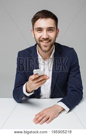Business Concept - Portrait handsome happy handsome business man in suit playing moblie phone and smiling with laptop at work office. White Background.
