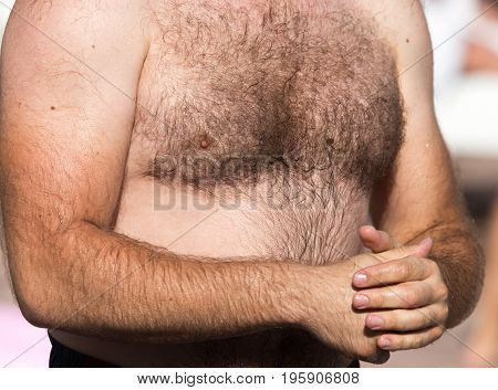 Hairy chest of a man in the open air .