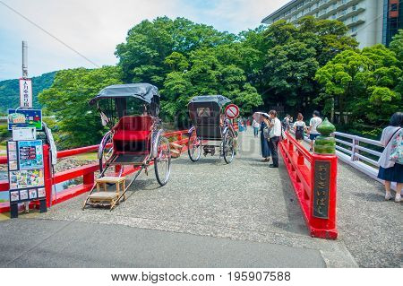HAKONE, JAPAN - JULY 02, 2017: Unidentifies people over a red bridge at the river at Odawara, transition point to Hakone.