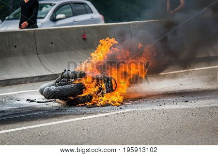 Traffic accident between a car and a motorcycle, after crash the motorcycle has been embraced with fire.