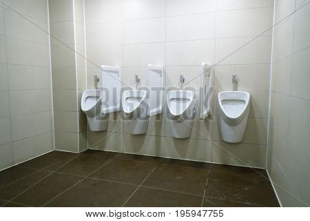 modern restroom interior with white urinal row
