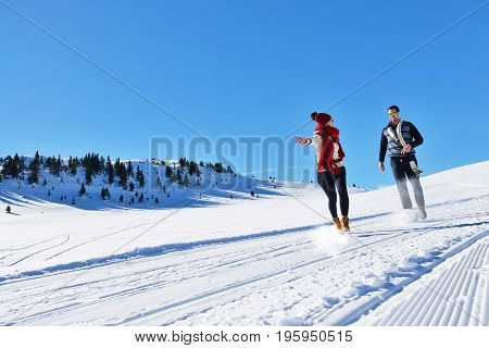 Cheerful young couple having fun in winter park.