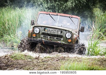 LUBOTIN UKRAINE - JULY 23 2016: RFC Ukraine Wild Boar Challenge 2016. Custom built Off-road Trophy UAZ 469 leaves the swamp at high speed.