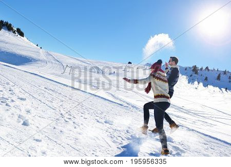Cheerful young couple having fun in winter park.