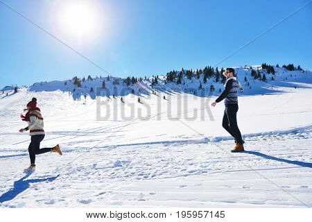 Cheerful young couple having fun in winter park.