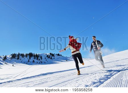 Cheerful young couple having fun in winter park.
