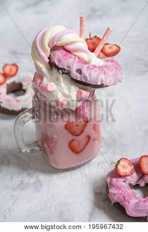 Pink strawberry freakshake milkshake with sweets donut and marshmallow