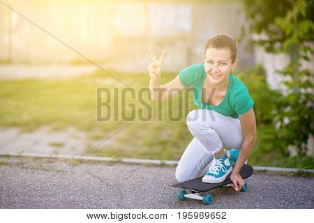 Beautiful girl rides on a highway on Longboard scenic street. Solar toning. Close-up portrait. Healthy lifestyle.