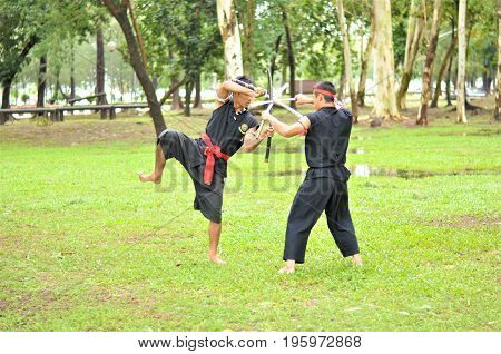 PUKED,THAILAND - AUGUST 28: Master trick of ancient fighter on August 28, 2011 in Puked Thailand.
 Master show how to trick of fight with swords.