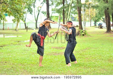 PUKED,THAILAND - AUGUST 28: Master trick of ancient fighter on August 28, 2011 in Puked Thailand.
 Master show how to trick of fight with swords.