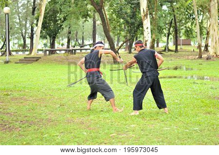 PUKED,THAILAND - AUGUST 28: Master trick of ancient fighter on August 28, 2011 in Puked Thailand.
 Master show how to trick of fight with swords.