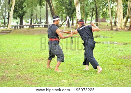 PUKED,THAILAND - AUGUST 28: Master trick of ancient fighter on August 28, 2011 in Puked Thailand.
 Master show how to trick of fight with swords.