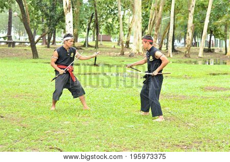 PUKED,THAILAND - AUGUST 28: Master trick of ancient fighter on August 28, 2011 in Puked Thailand.
 Master show how to trick of fight with swords.