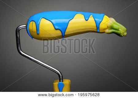 Paint Roller Zucchini With Pouring Sky Blue Paint On Gray Background. Fashion Food Concept.creative