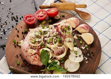 Fresh chicken fillet with fresh vegetables mushrooms onion rosemary and seasoning spices on dark wooden board. Culinary cooking ingredients. Helthy diet food.