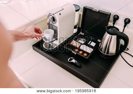 Coffee preparation concept at home by a coffee machine. Close-up image of a man's hands preparing espresso at morning.