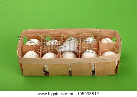 White Chicken Eggs In Wooden Container Over Green