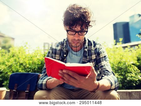 lifestyle, creativity, freelance, inspiration and people concept - creative man with notebook or diary writing sitting on city street bench
