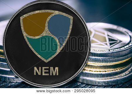 Coin Cryptocurrency Nem On The Background Of A Stack Of Coins. Crypto Token Xem.