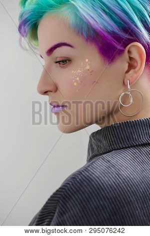 A Young Woman With Short Hair, A Pixie Bob Haircut, Different Colored Hair, Blue, Green, Violet.