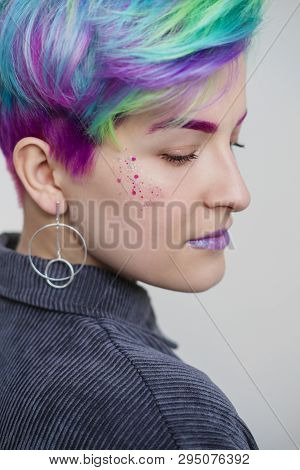 A Young Woman With Short Hair, A Pixie Bob Haircut, Different Colored Hair, Blue, Green, Violet.